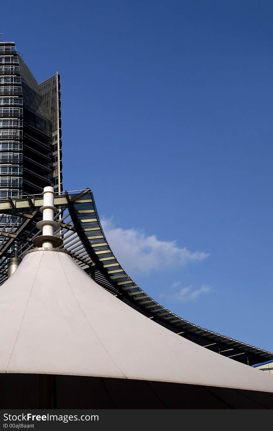 White canopy and building have similar  curved outline. White canopy and building have similar  curved outline