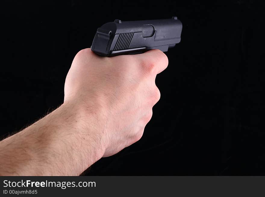 Black gun in hand isolated on black background. Black gun in hand isolated on black background