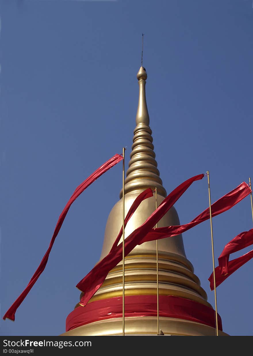 Golden Cheddi with red flags at Buddhist temple in Thailand. Golden Cheddi with red flags at Buddhist temple in Thailand.