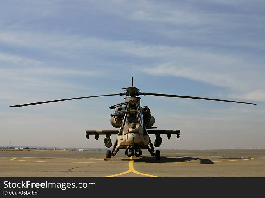 Rooivalk helicopter pre-flight standing on apron with cloudy background. Rooivalk helicopter pre-flight standing on apron with cloudy background