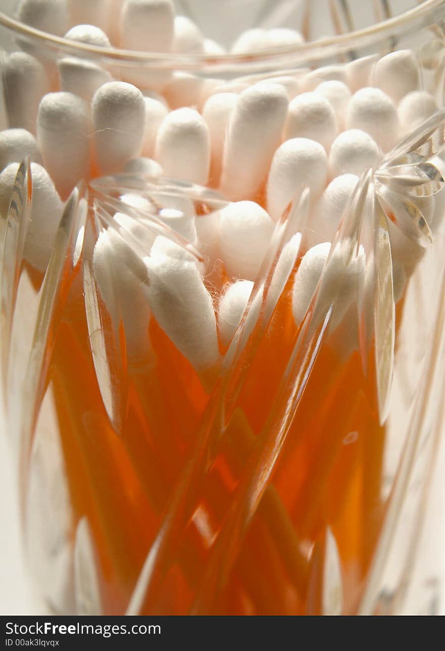 Figured glass can with orange hygienics sticks close-up. Figured glass can with orange hygienics sticks close-up