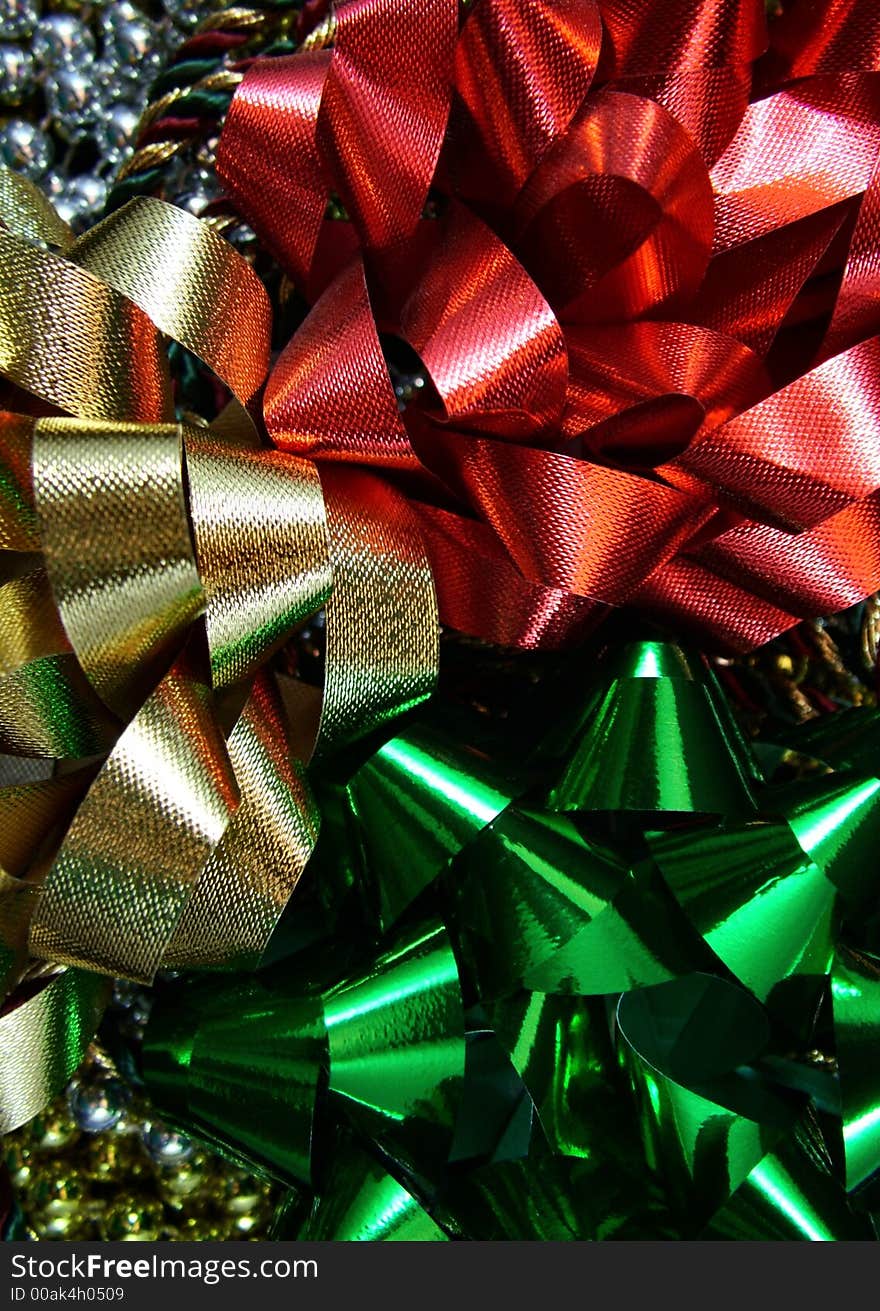 Red, gold, and green holiday bows on top of gold and silver beads