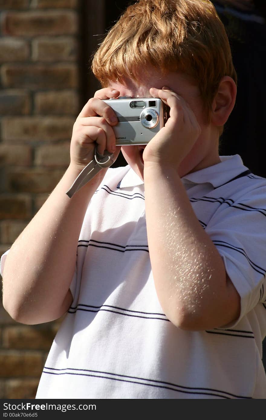 Young boy taking a photograph with his first digital camera. Young boy taking a photograph with his first digital camera