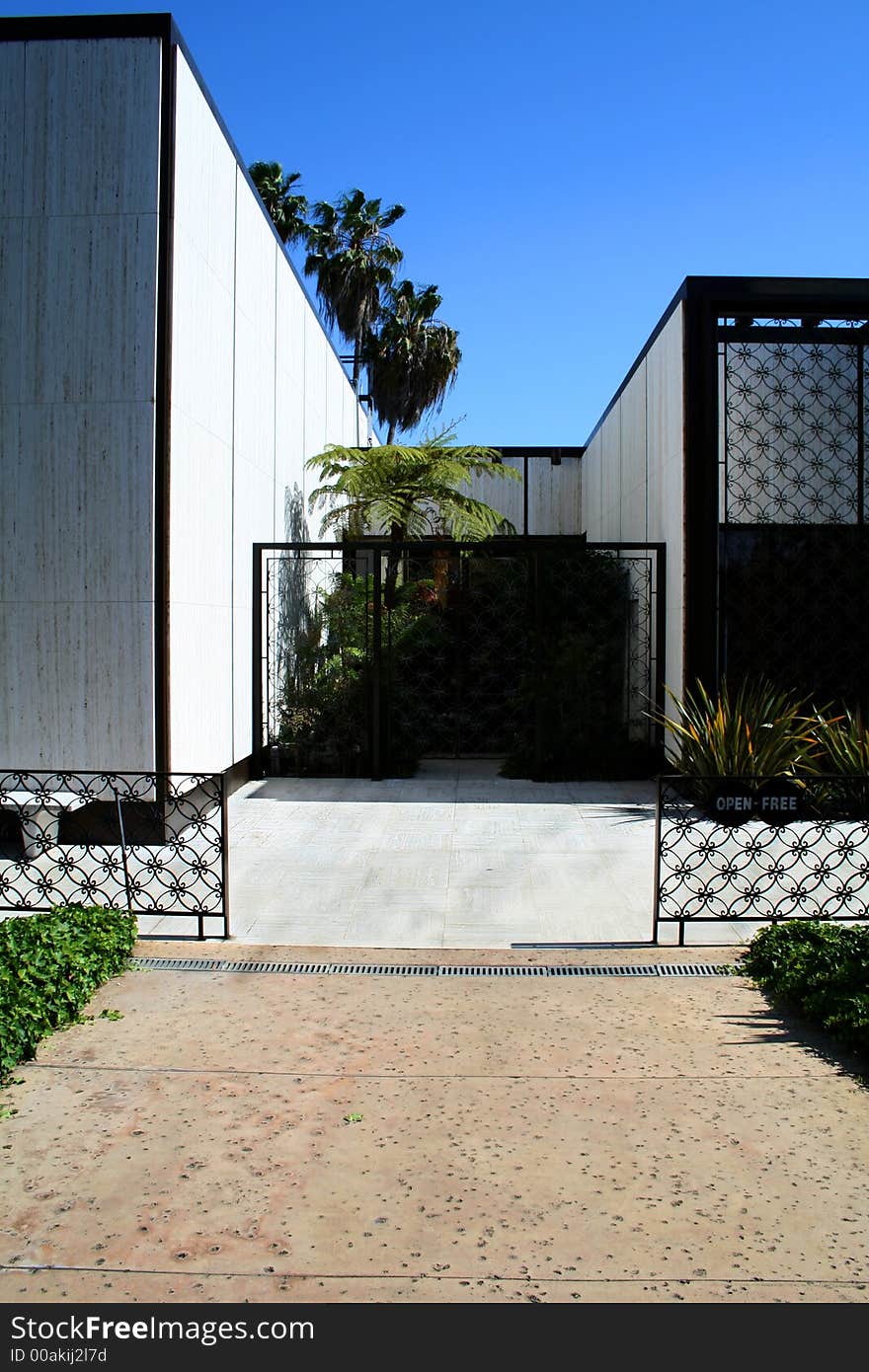 Modern white building with black fencing details and the walls are out of smooth stone. Modern white building with black fencing details and the walls are out of smooth stone.