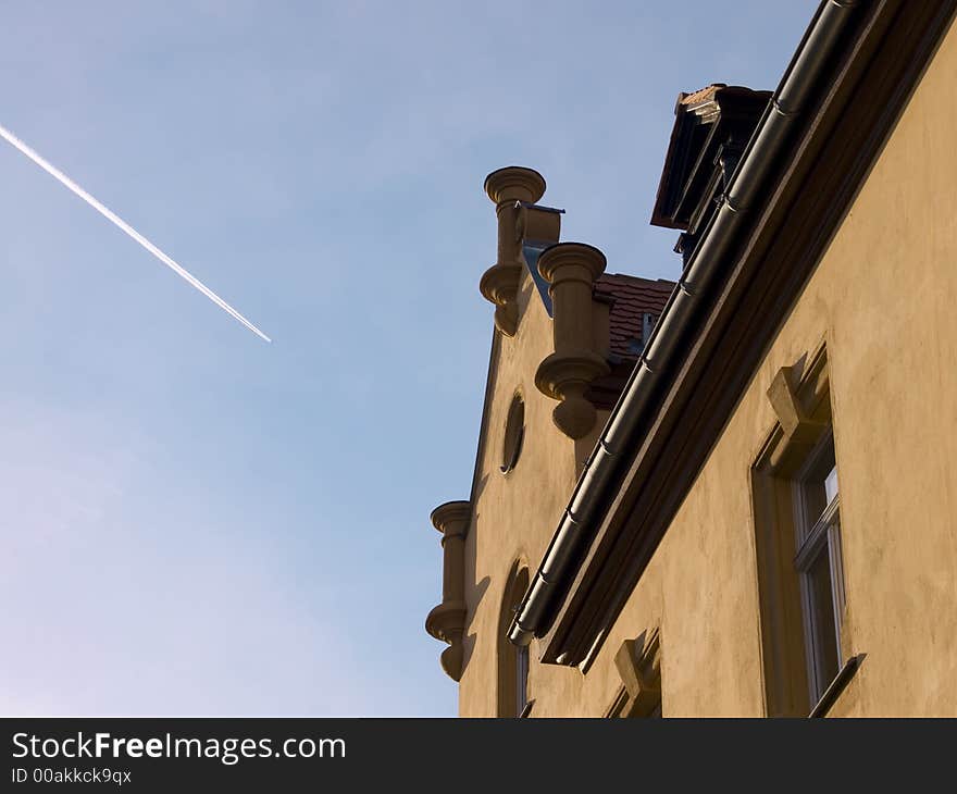 Gable of an old house with condensation trail. Gable of an old house with condensation trail