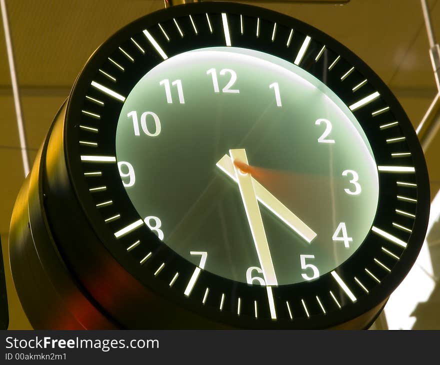 Time passing by in a wall clock with blurred seconds hand