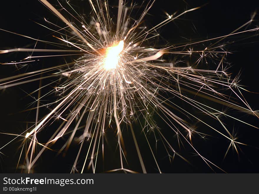 Burning sparkler at night with black background