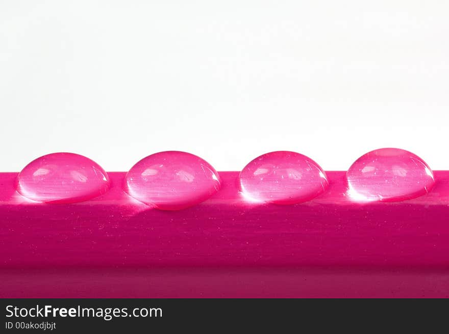 Four tiny water drops on a pencil