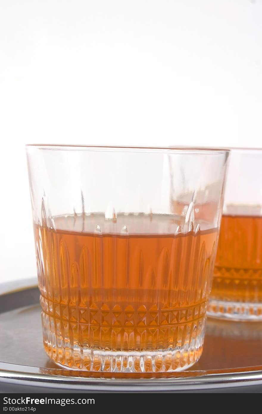 Two glasses of whiskey on a silver tray (one of them is hidden behind the other)