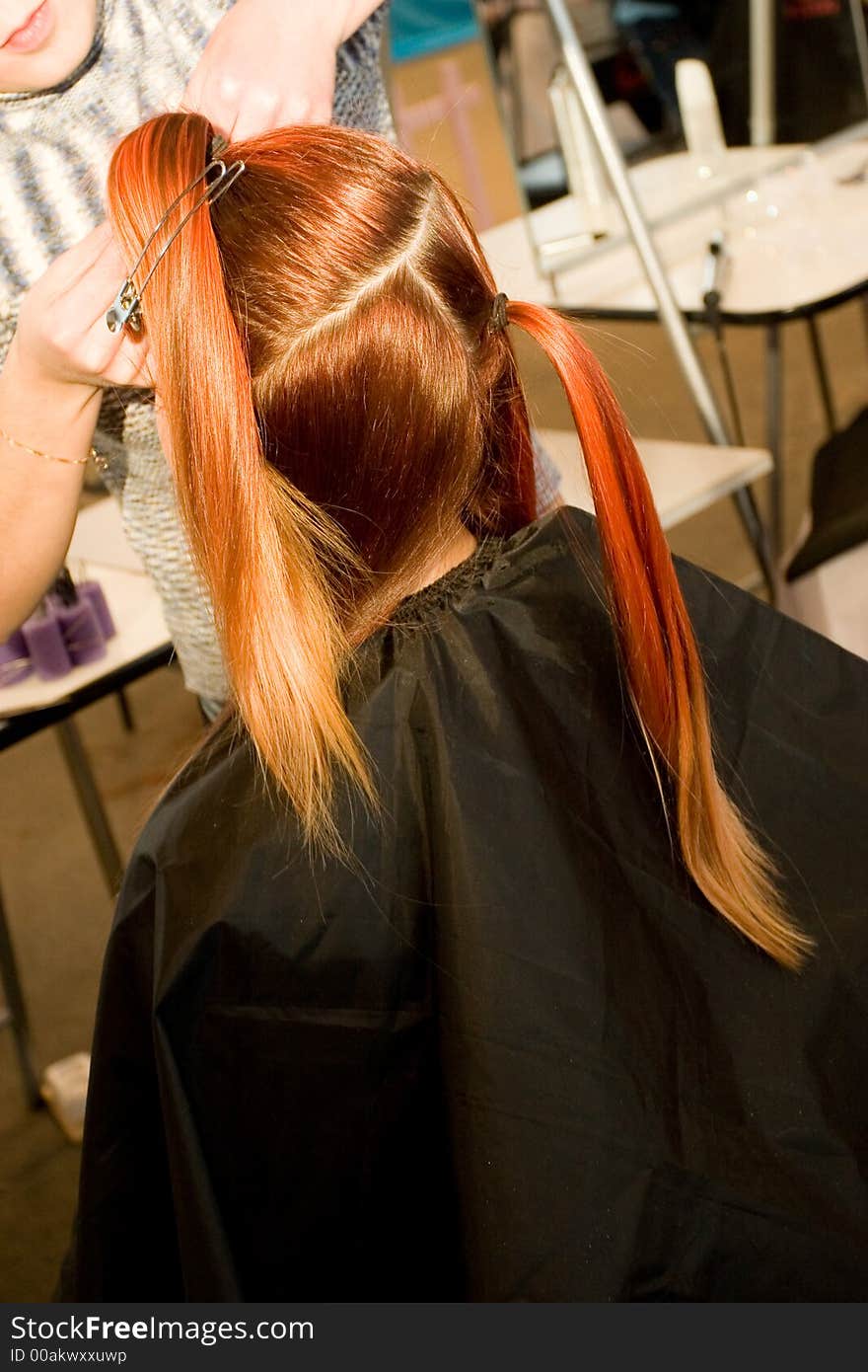 Woman coiffure. Hairdresser does young girl a hairstyle.