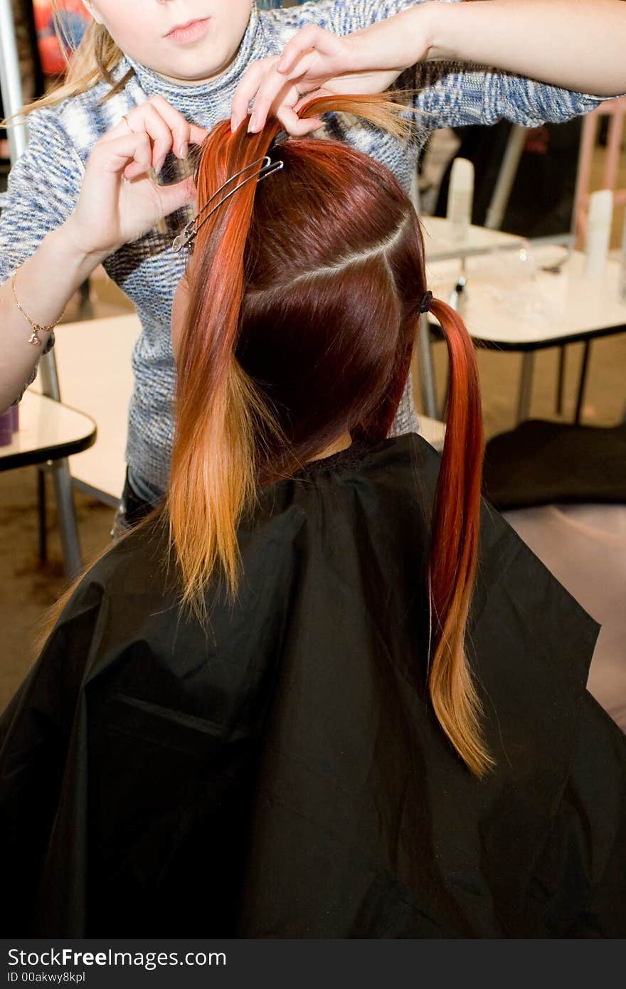 Woman coiffure. Hairdresser does young girl a hairstyle.