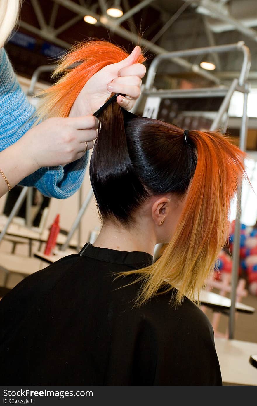 Woman coiffure. Hairdresser does young girl a hairstyle.