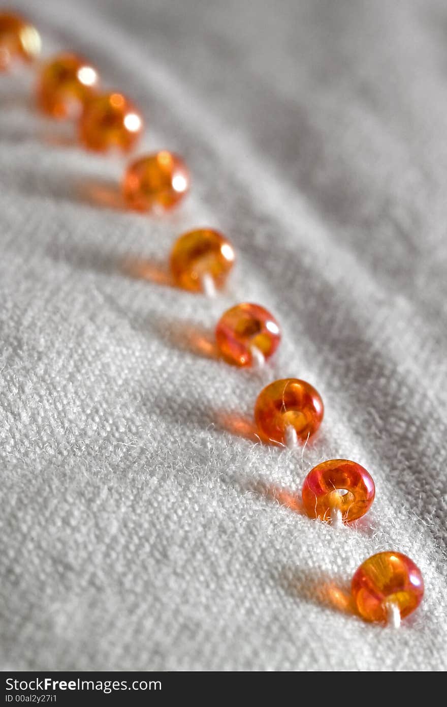 Plastic beads on white cotton