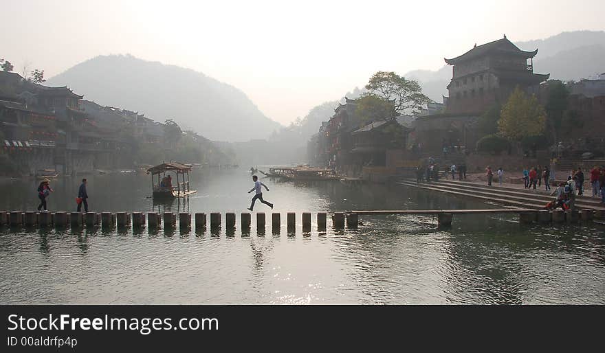 Chinse folk crossing bridge make from many stones in old village. Chinse folk crossing bridge make from many stones in old village