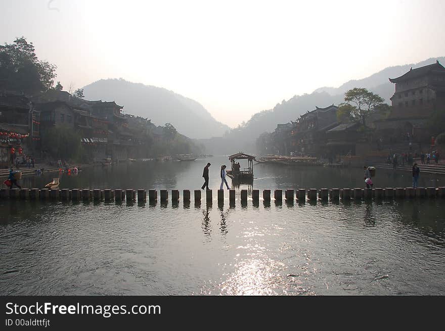 Chinse folk crossing bridge make from many stones in old village. Chinse folk crossing bridge make from many stones in old village