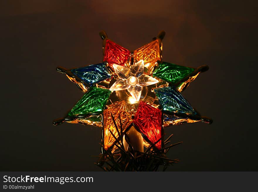 Closeup of a christmas tree star high atop a tree