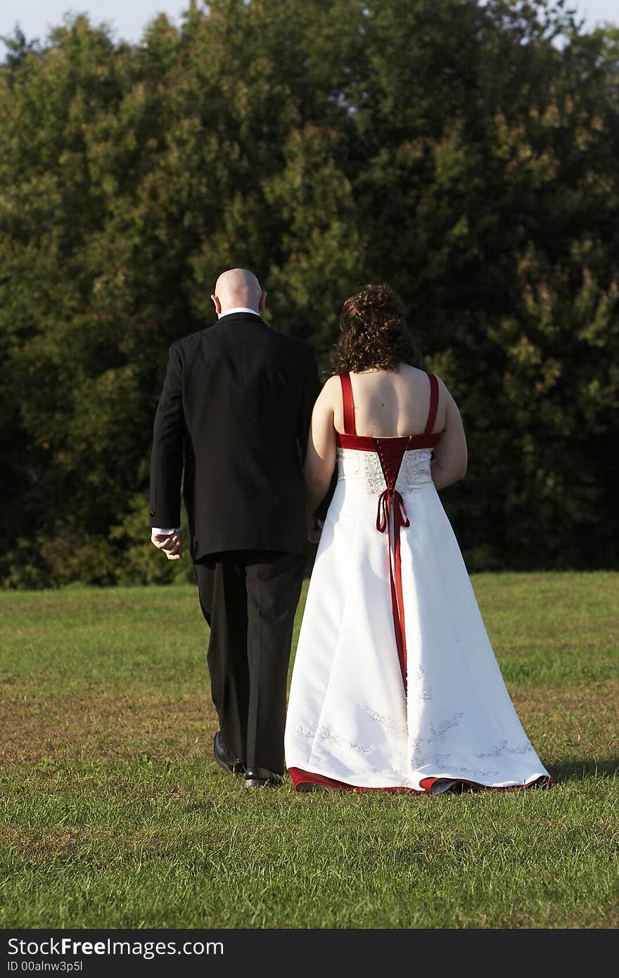 A bride and groom walking away from the camera. A bride and groom walking away from the camera.