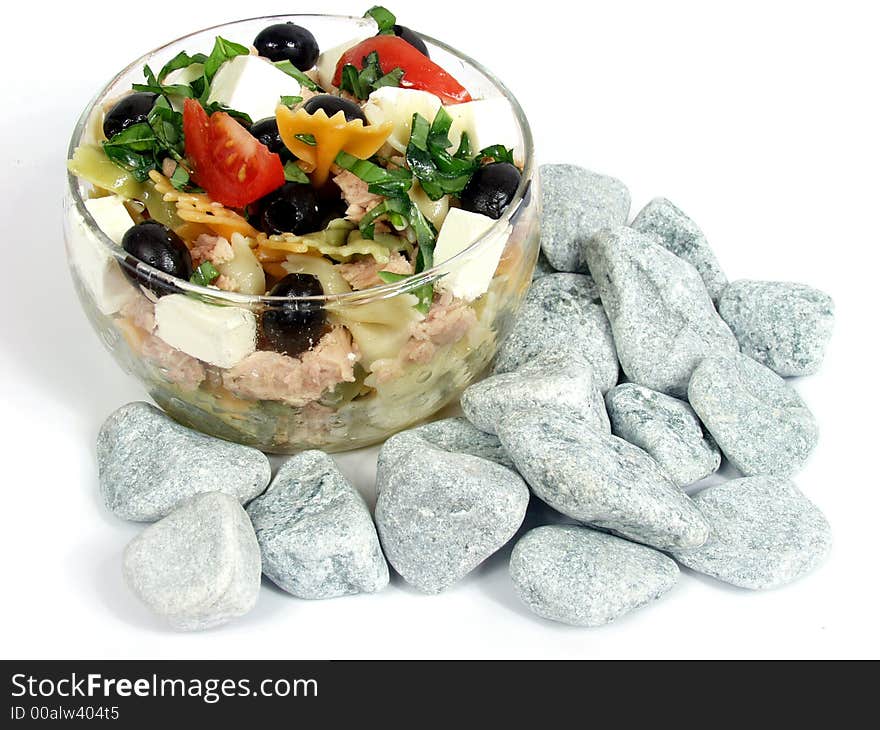 Pasta salad on glass bowl with fetta cheese and olives