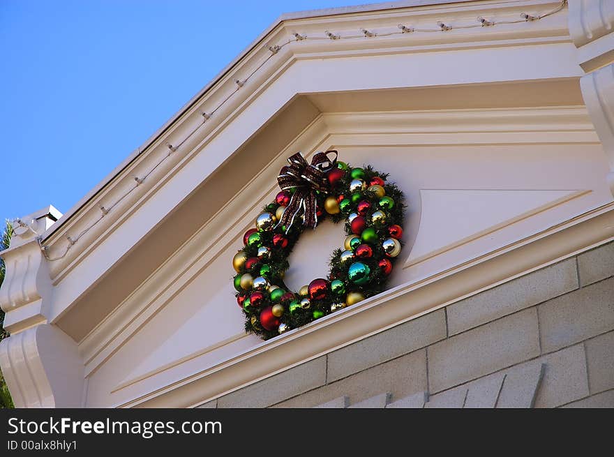 A red, green, blue christmas wreath on a building