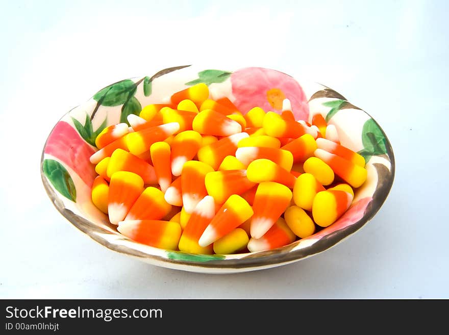 Bowl of candy corn on a white background.