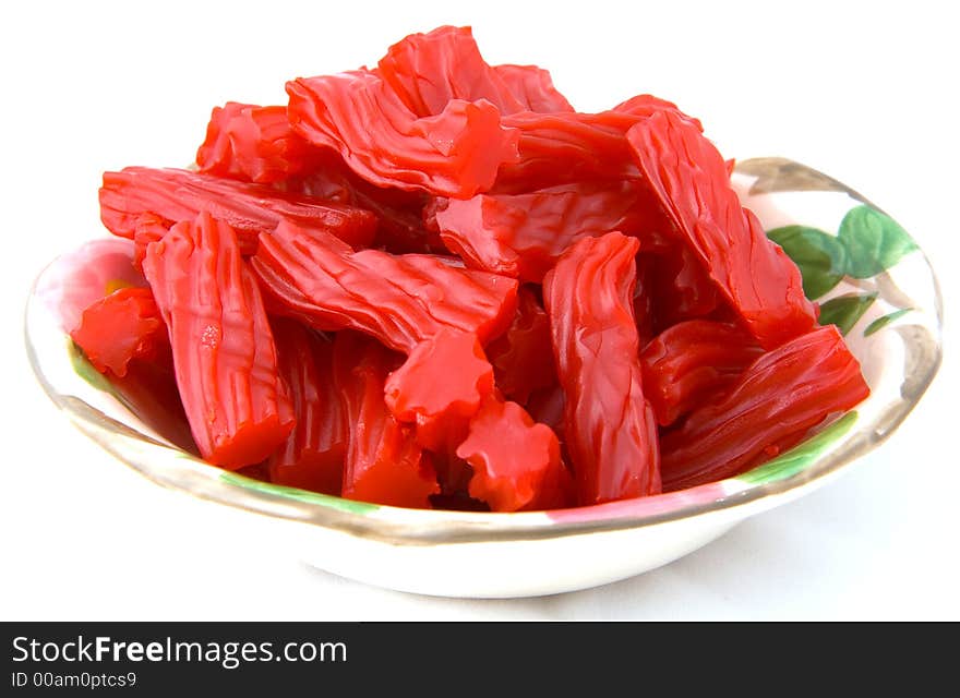 Bowl of raspberry candy on a white background.