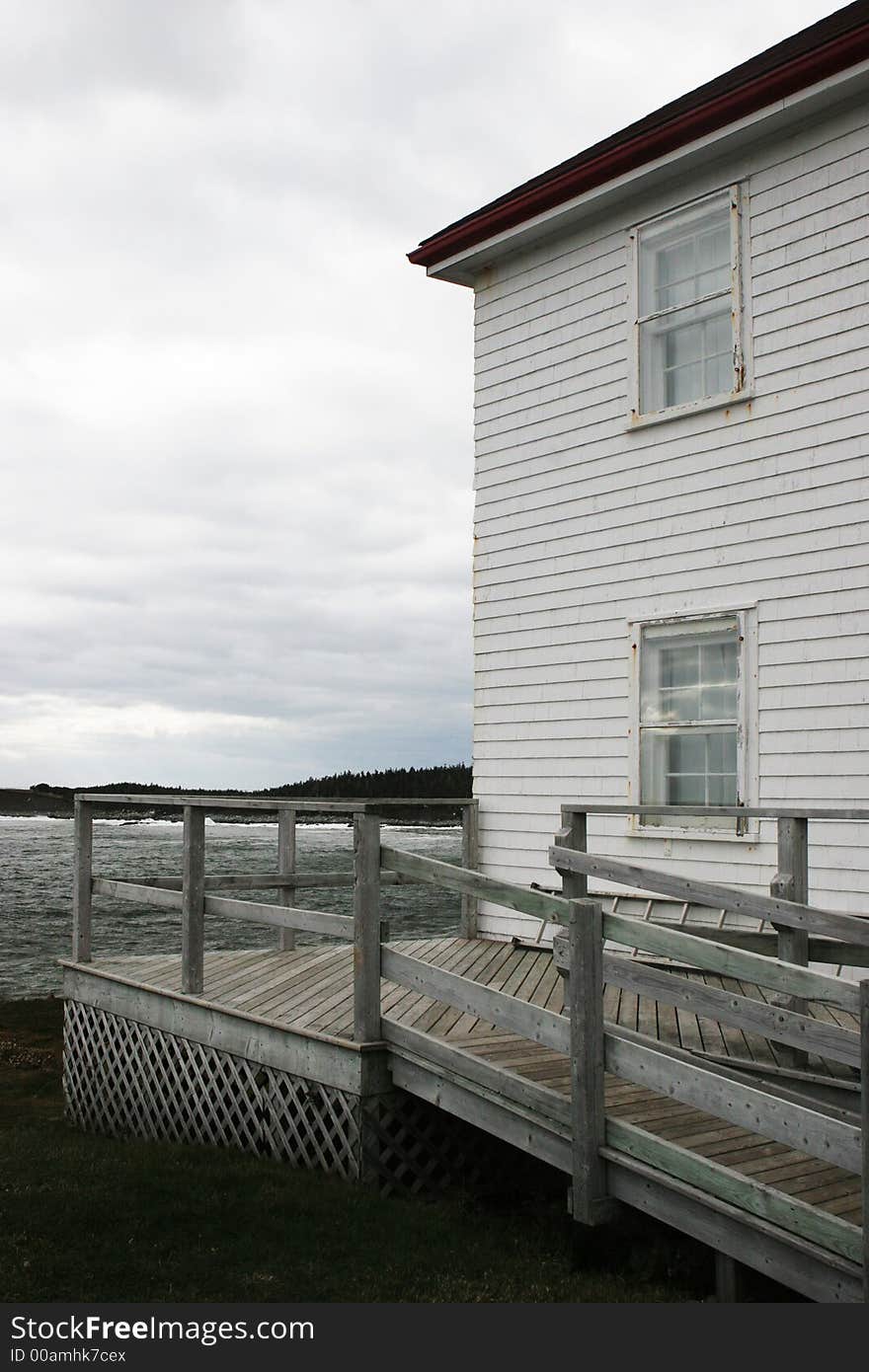 White weather board building overlooking the ocean