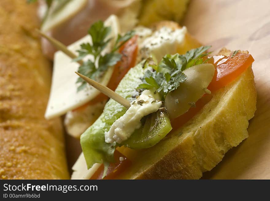 Small sandwich with tomato, cheese, kiwi and olive close up. Small sandwich with tomato, cheese, kiwi and olive close up