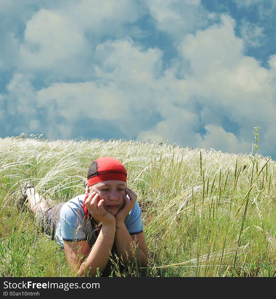 Relaxing girl in grass on blue background