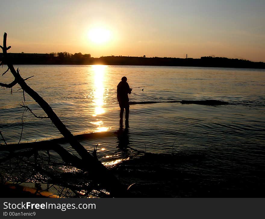 Man Fishing At Sunset River