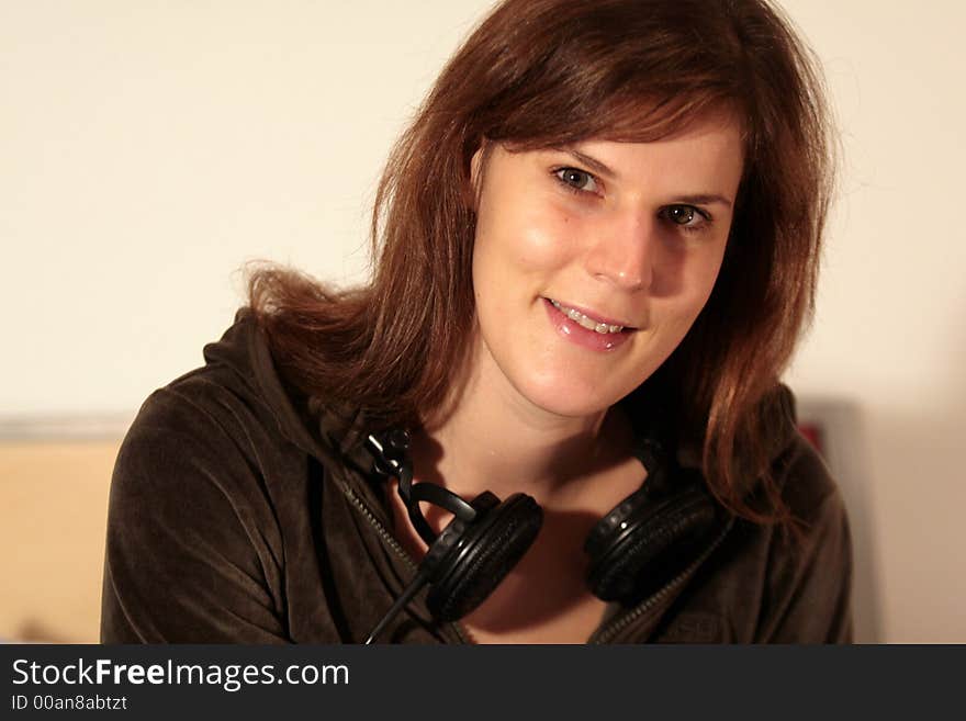 A young trendy woman with her headphones around her neck. A young trendy woman with her headphones around her neck.