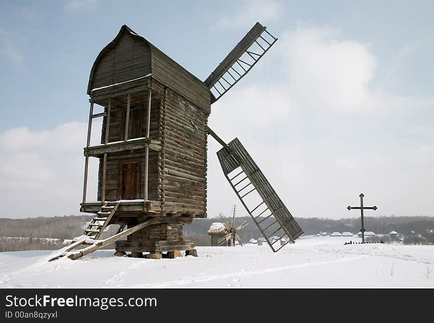 Old wooden windmiils on the snowy hill