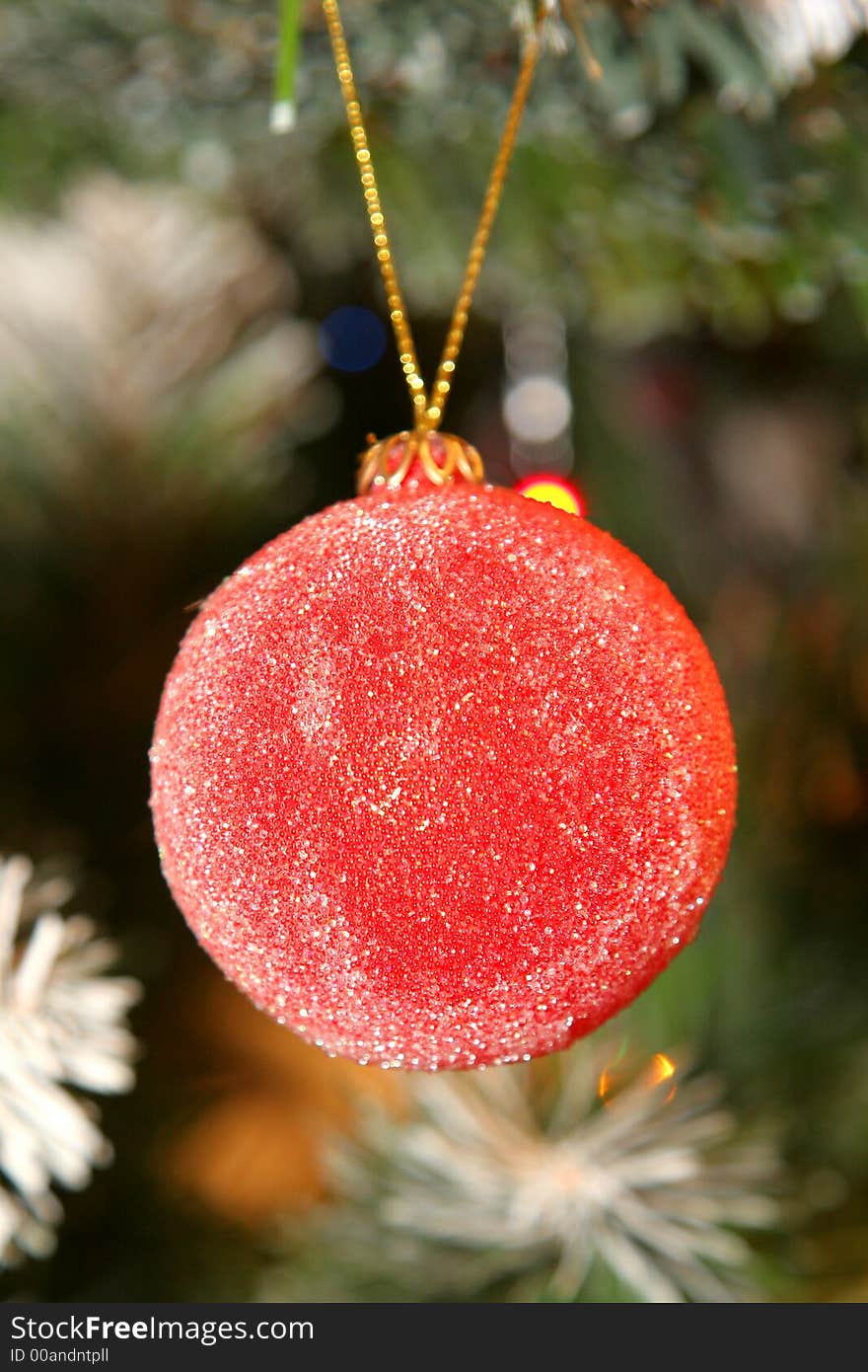 Christmas decorative ball with tree and lights in background