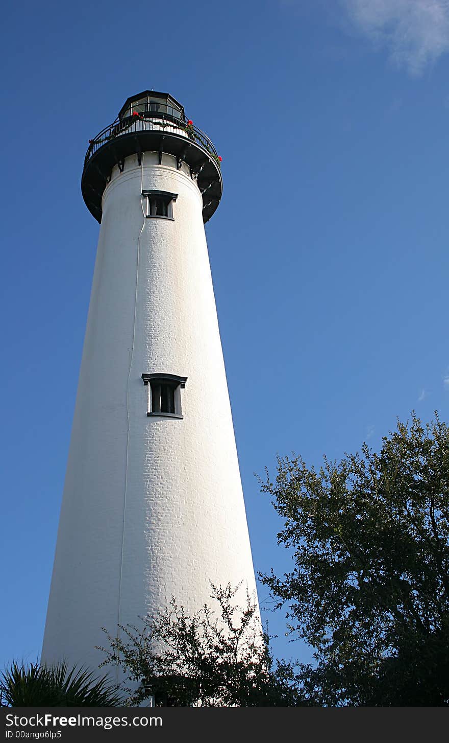 A white lighthouse against the blue sky at beach. A white lighthouse against the blue sky at beach