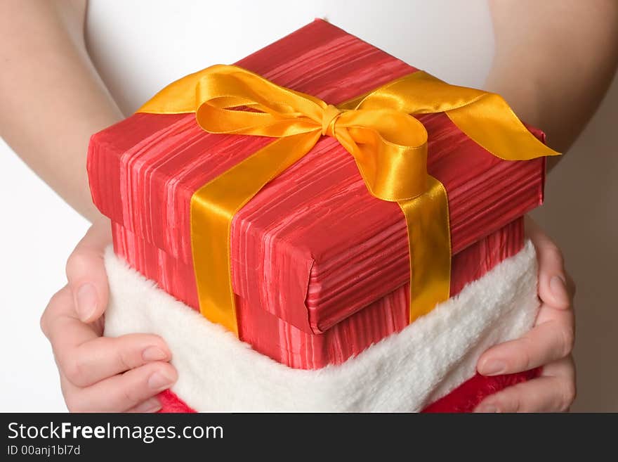 Girl hand holding a christmas present in red hat. Girl hand holding a christmas present in red hat