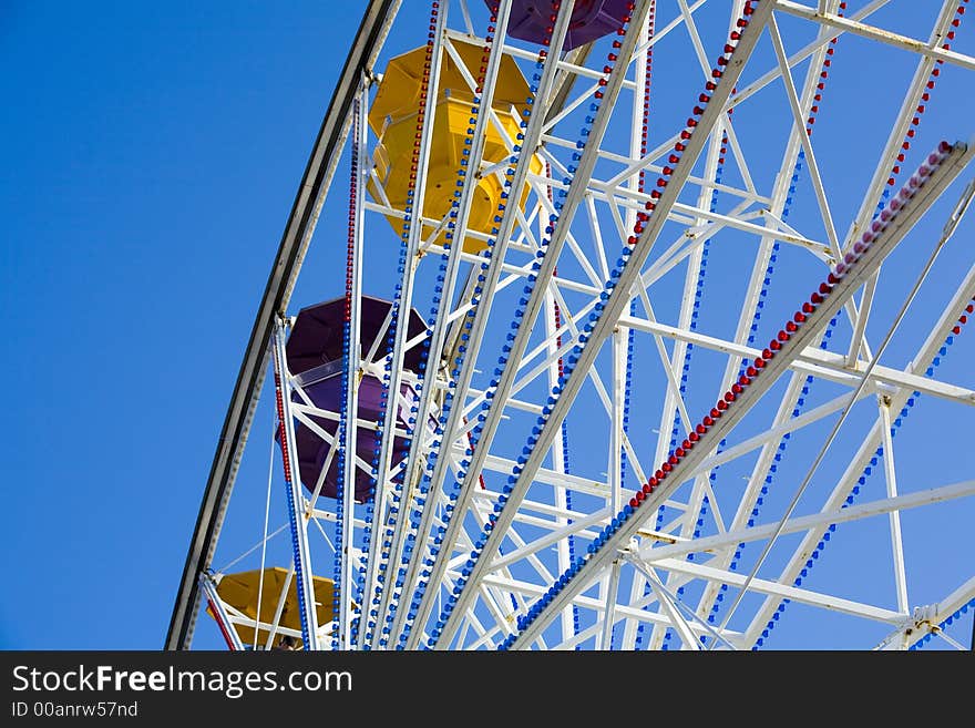 Shot of a ferris wheel with a bright blue sky.