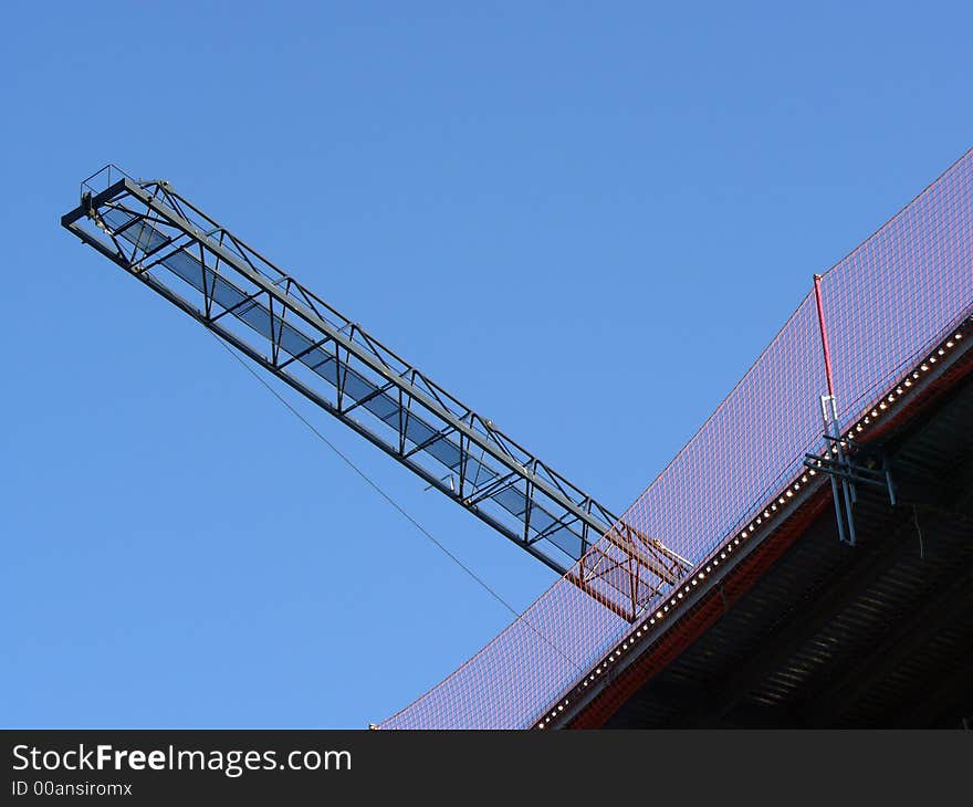 Abstract view of a crane with its arm towering over a building site. Abstract view of a crane with its arm towering over a building site