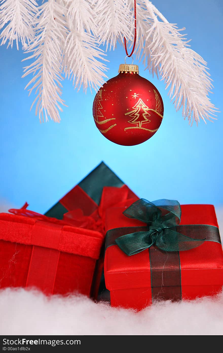 Christmas gifts and red ornament on white tree