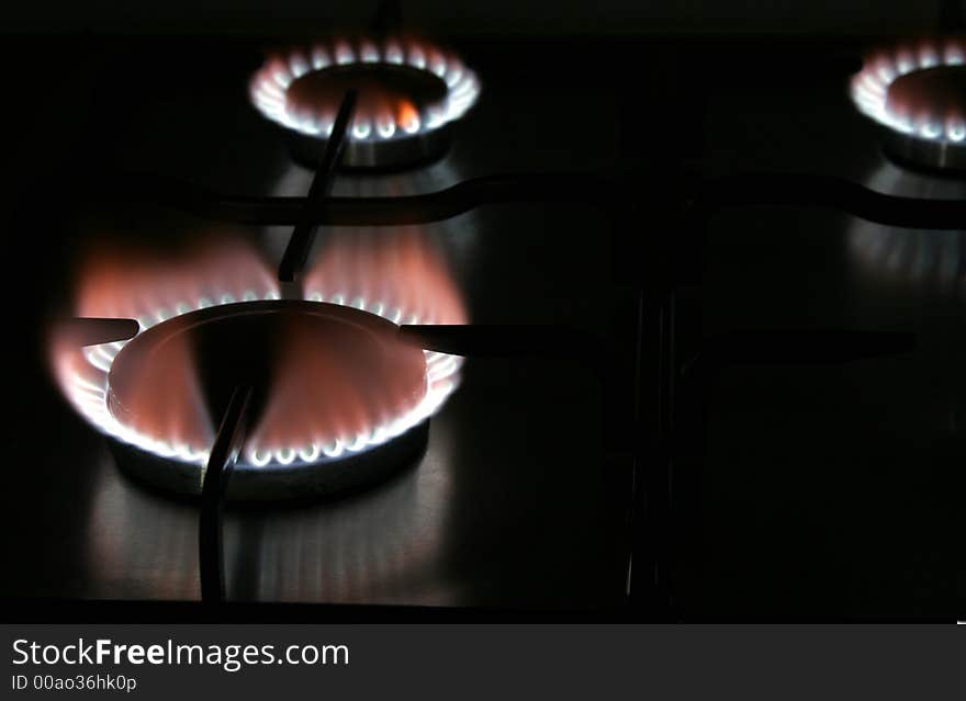 Blue Flame Of A Stove Burner In Darkness Illustrating Combustion Of Gas. Blue Flame Of A Stove Burner In Darkness Illustrating Combustion Of Gas