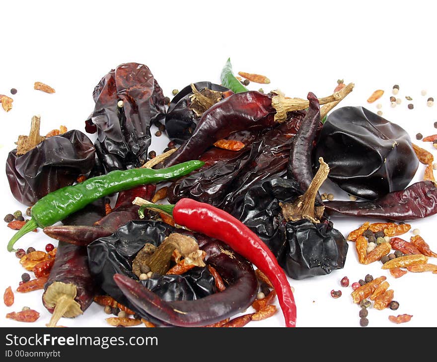 Cayena and ground pepper on white background