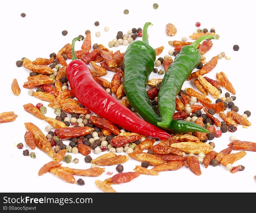 Green, red pepper and ground pepper on white background