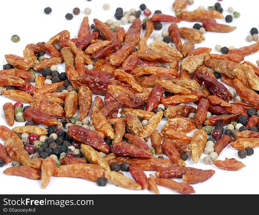 Cayena and ground pepper on white background