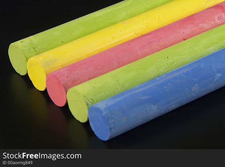 Some colorful chalks on a black background