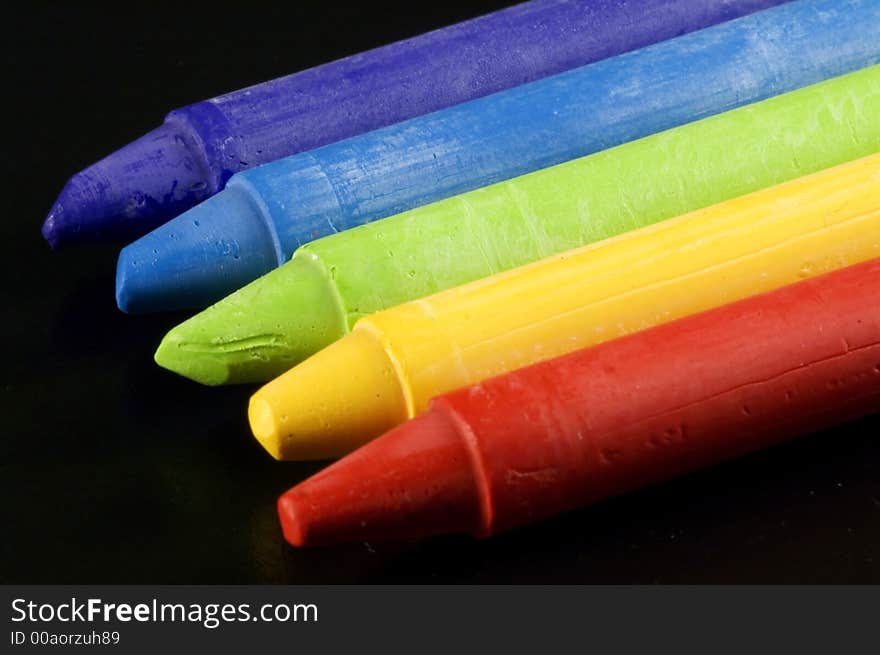 Some colorful wax colors on a black background. Some colorful wax colors on a black background