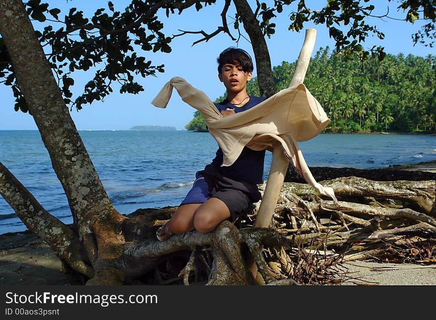 Asian Boy Dressing On The Beach.