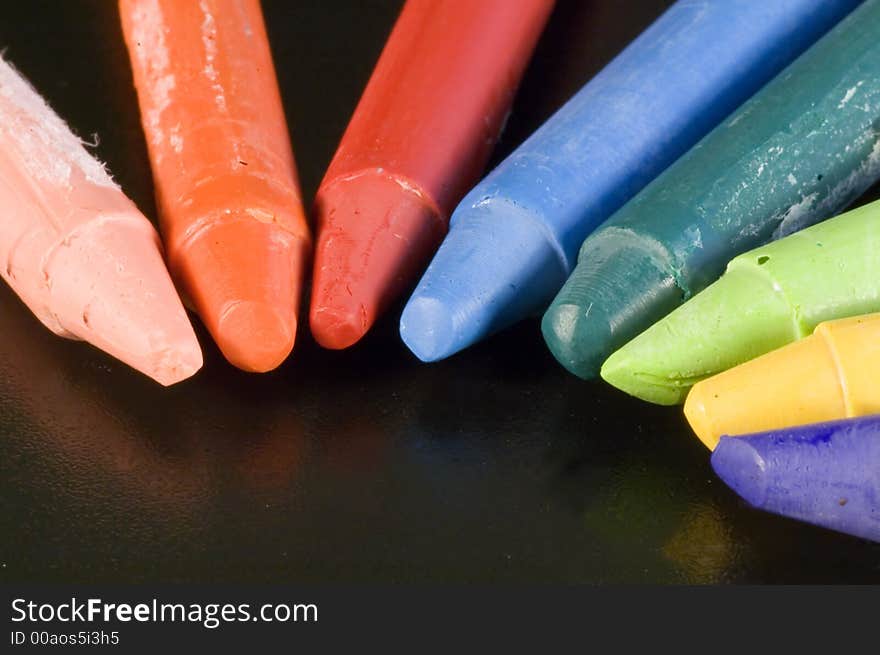 Some colorful wax colors on a black background. Some colorful wax colors on a black background