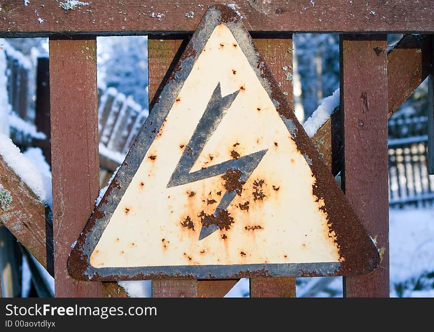 Sign dangerously on a wooden fence