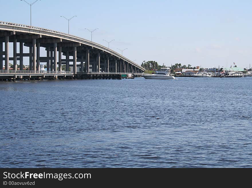 Bridge over river with boat crossing underneath.