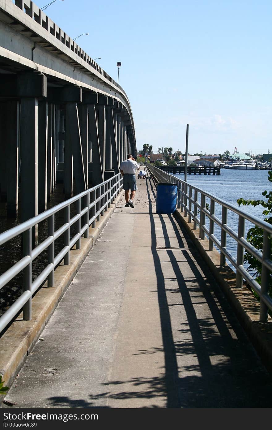 Man walking along fishing bridge. Man walking along fishing bridge.