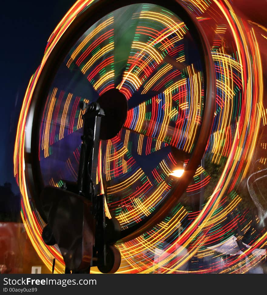 A ferris wheel that appears to be moving at top speed. A ferris wheel that appears to be moving at top speed