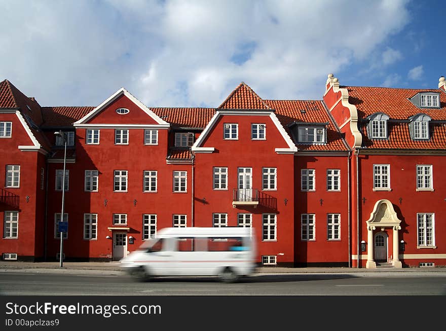 Traffic , cars speeding in front of an old red building / house (low shutter speed). Traffic , cars speeding in front of an old red building / house (low shutter speed)